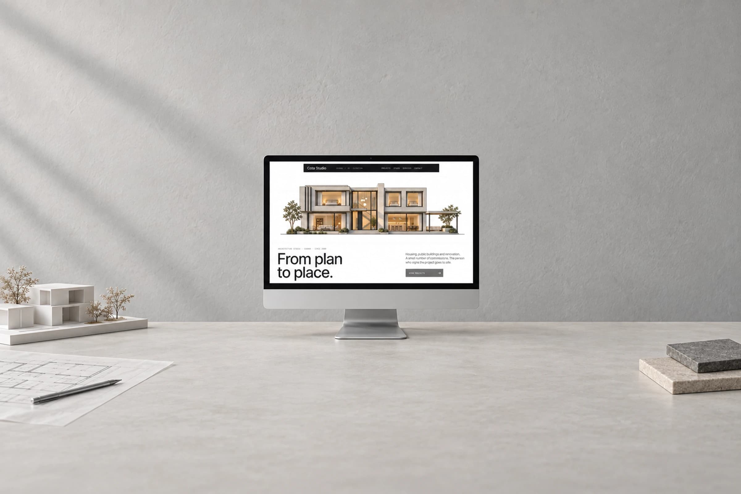 A centred monitor showing Casa Patio on a drafting table, with generous grey wall and desk space around it.